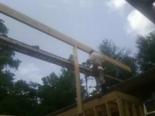 Carpenter setting a ridge beam over a new addition frame — Ice Dam Removal by Roofing Brothers in Bernville