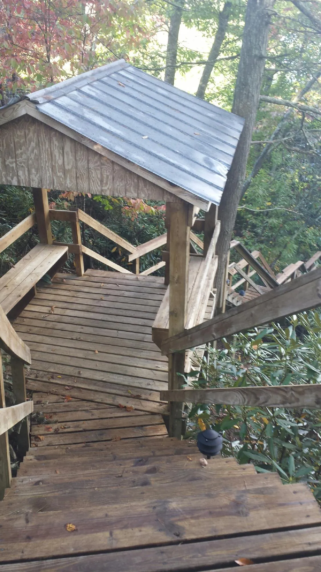 Metal roofed shelter over wooden steps on a wooded walkway — Skylight Repair & Installation work by our crew in Bernville