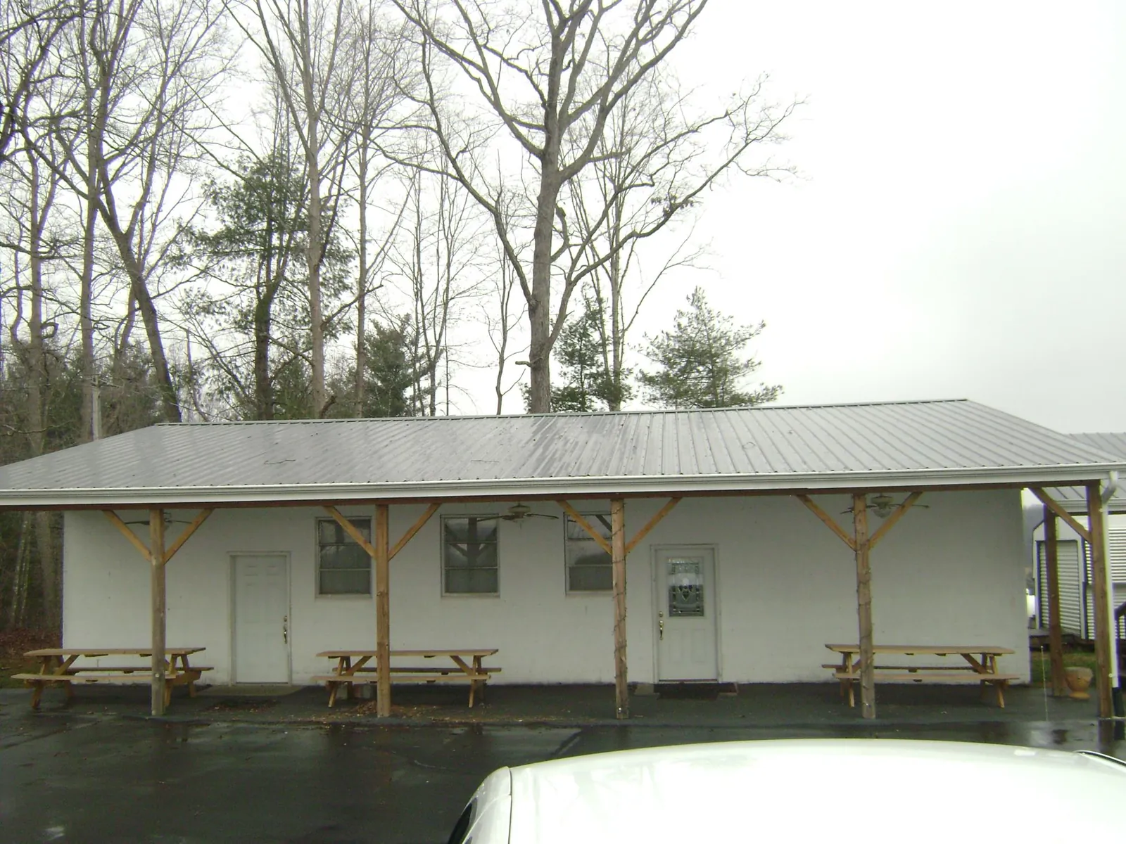 Gray metal roof over a block building with a timber post porch in Bernville